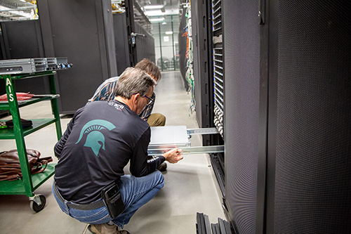 Two system administrators install a new Grace Hopper node in the data center