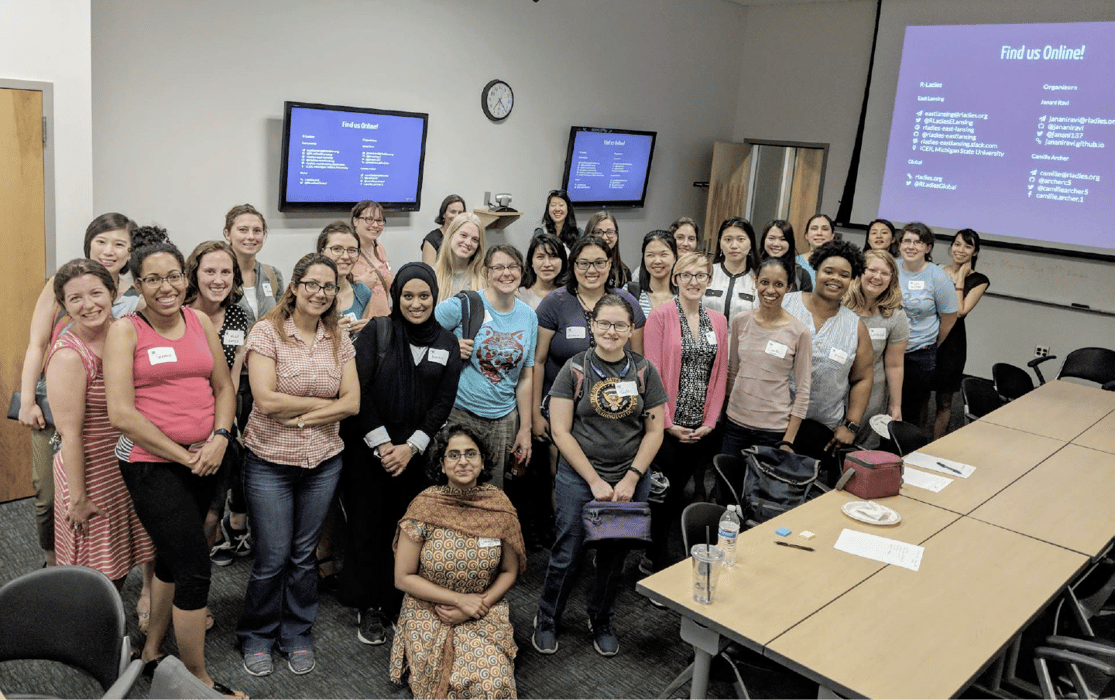 Members of R Ladies standing a a room with several screens