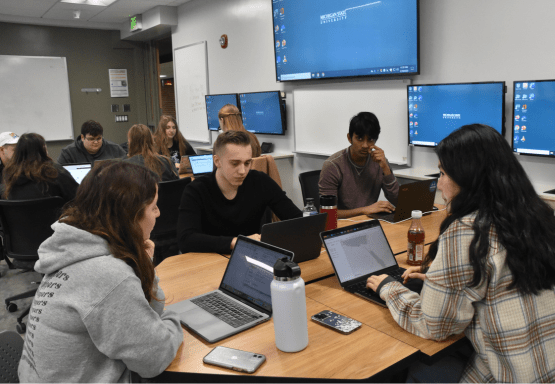 This image shows a group of James Madison College students working on research for the Human Rights Data Science Lab.