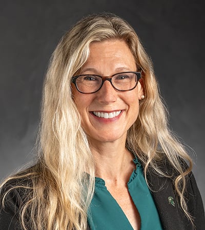 Headshot of Laura Lee McIntyre on a dark gray background.