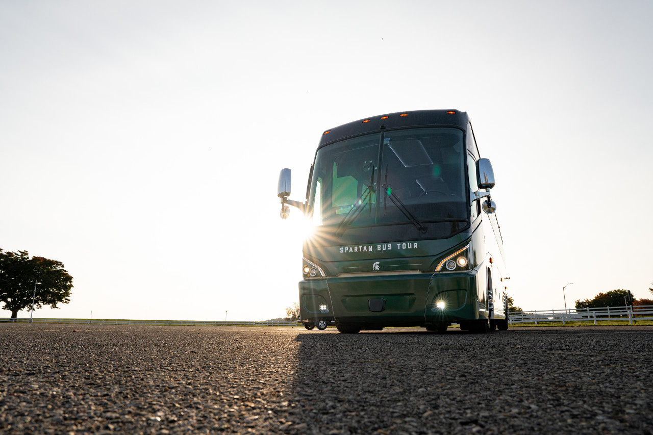 Front of passenger bus against sunrise.