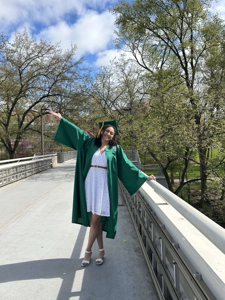MSU student in graduation gown on bridge