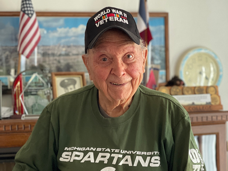 Ceo wearing a World War II baseball cap smiling at the camera