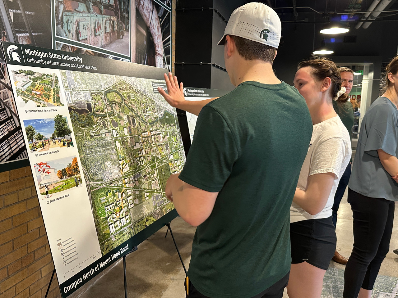 Two people looking at a map on an easel.