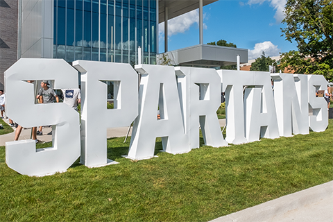 Spartans written in large white block letters on a lawn