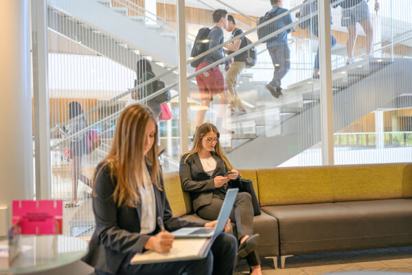 Students working on a laptop and a cellphone in the atrium and classrooms of the Minskoff Pavilion in the fall of 2019 at Michigan State University.