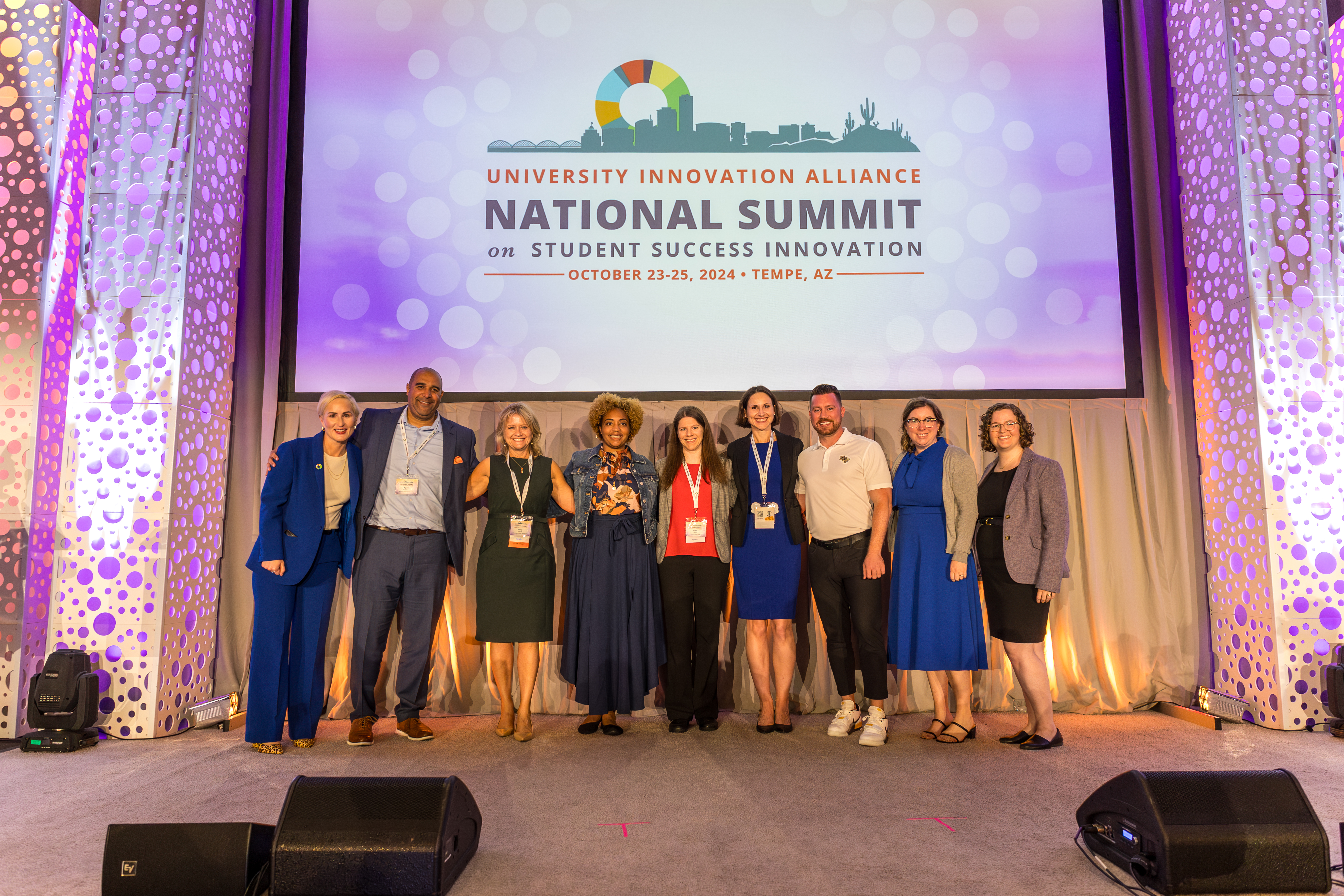 Group of past UIA fellows standing on a stage at the UIA summit in October.