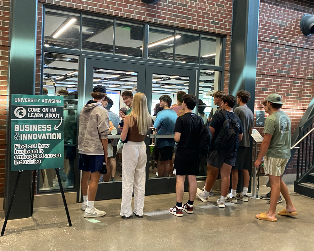 Exploratory students standing outside a classroom doorway waiting to get inside at the Colloquium event at the STEM building.