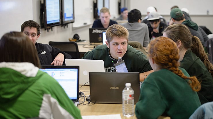 Groups of applied engineering students ? many of them wearing Spartan gear ? sit at study tables, deep in conversation.