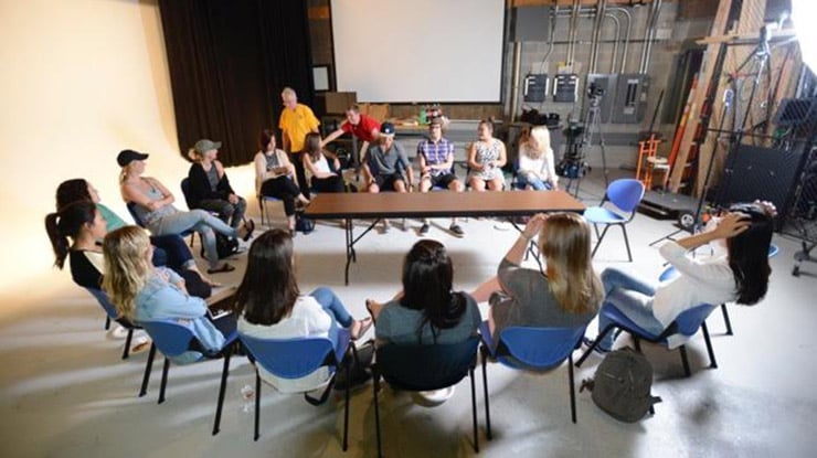 Students in the communication major at Michigan State University sit in a circle of chairs in a film studio.