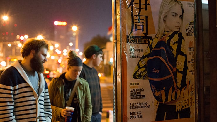 People stand by a large city ad featuring model Cara Delevingne that may have been designed by creative advertising majors.