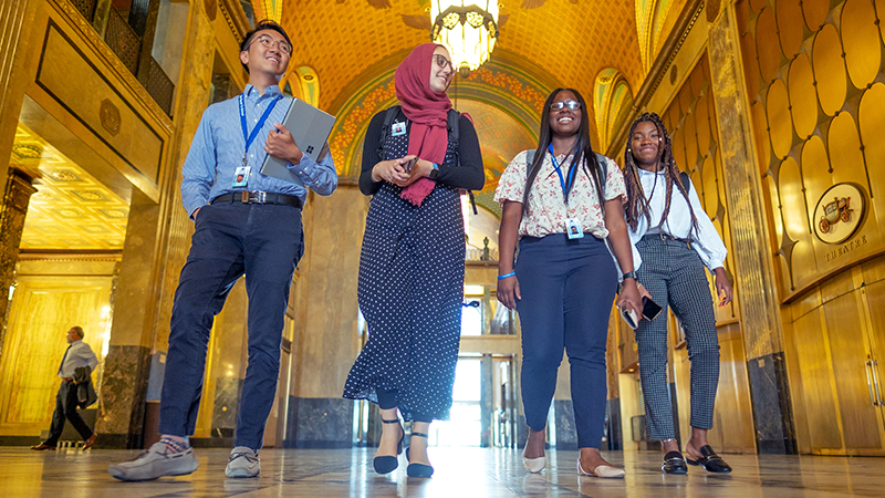 Four MSU students walk through the ornate Fisher Building in Detroit, representing the study of culture and politics, rights and civic life.