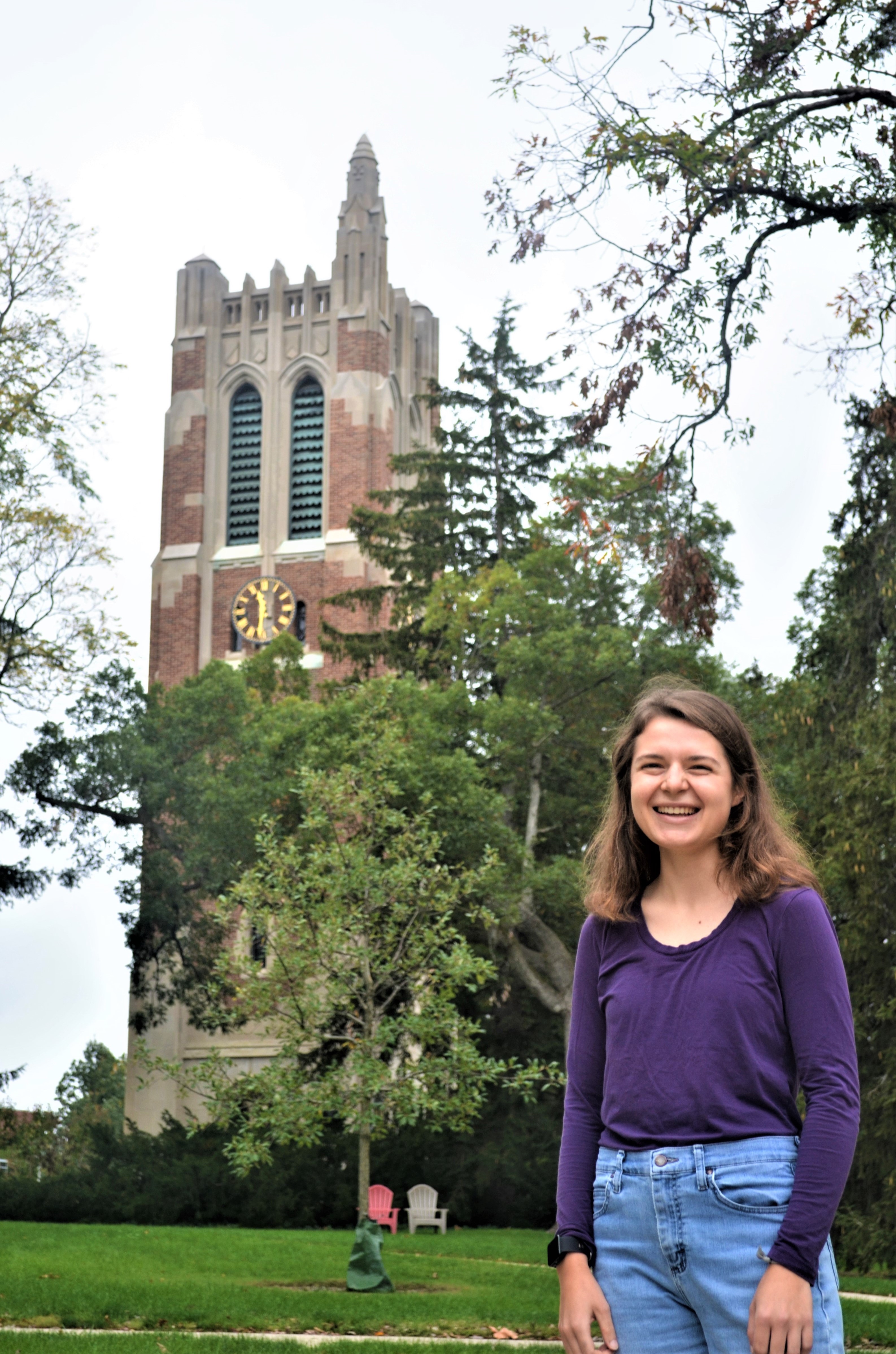 MSU alum Rachel Drobnak smiles on campus in front of Beaumont Tower.