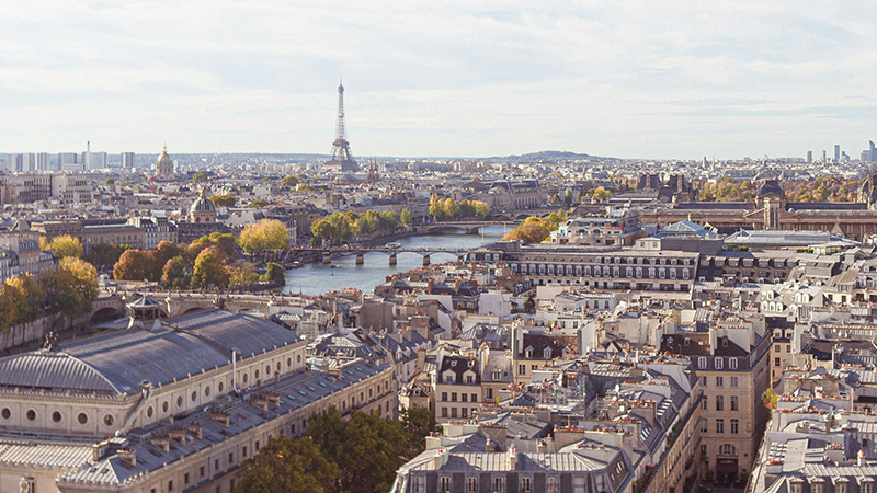 Paris cityscape with the Eiffel Tower and the Seine River overlooking historic rooftops, representing French education.