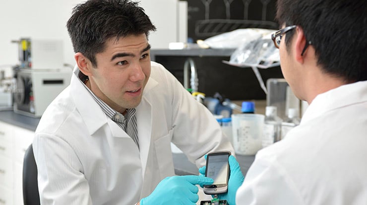 Two students working on a mechanical engineering degree collaborate in a lab.