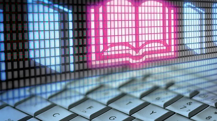 Close-up of a keyboard and an icon of a book, representing the professional writing major.