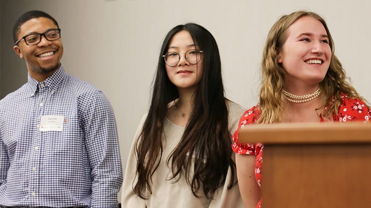 Three public relations degree students at Michigan State University give a presentation at the front of a classroom.