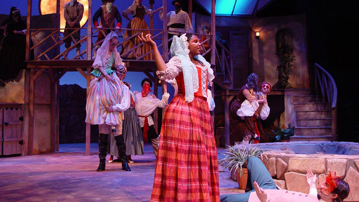 MSU theatre majors perform a play on stage in colorful costumes.