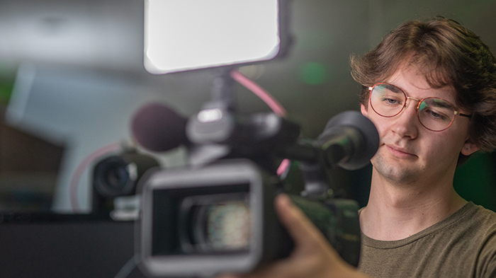 An MSU student reviews footage on the display of a professional video camera.