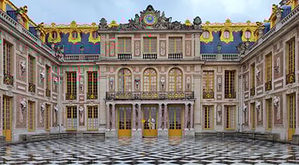 The opulent exterior of the Palace of Versailles in France, with golden accents, grand windows, and a checkerboard courtyard.
