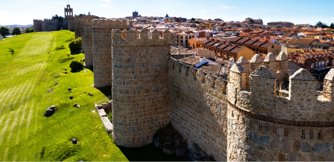 Medieval stone walls and towers overlooking the city of Ávila, Spain.