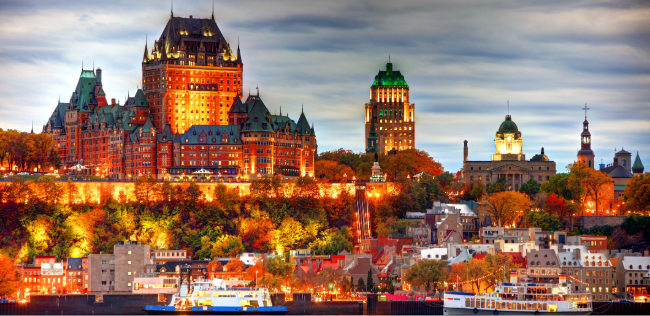 Château Frontenac and historic skyline illuminated at dusk above the St. Lawrence River in Québec City, Canada.