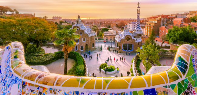 Colorful mosaic terrace overlooking the entrance pavilions of Park Güell in Barcelona, Spain.