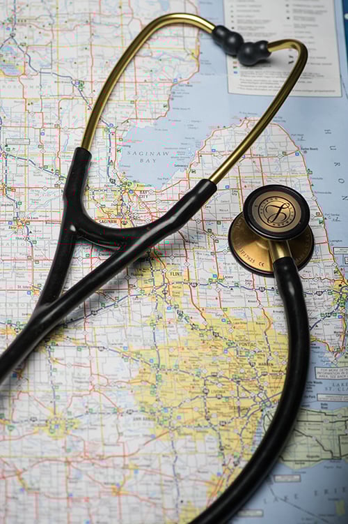 A stethoscope sitting on a map of Michigan