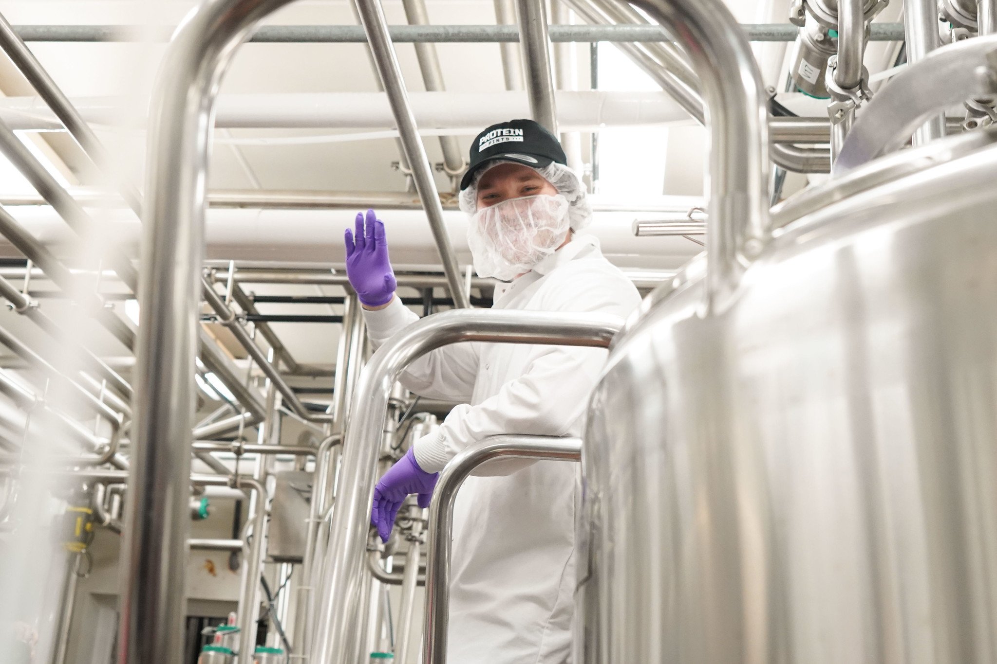 Protein Pints founder posing in diary factory.