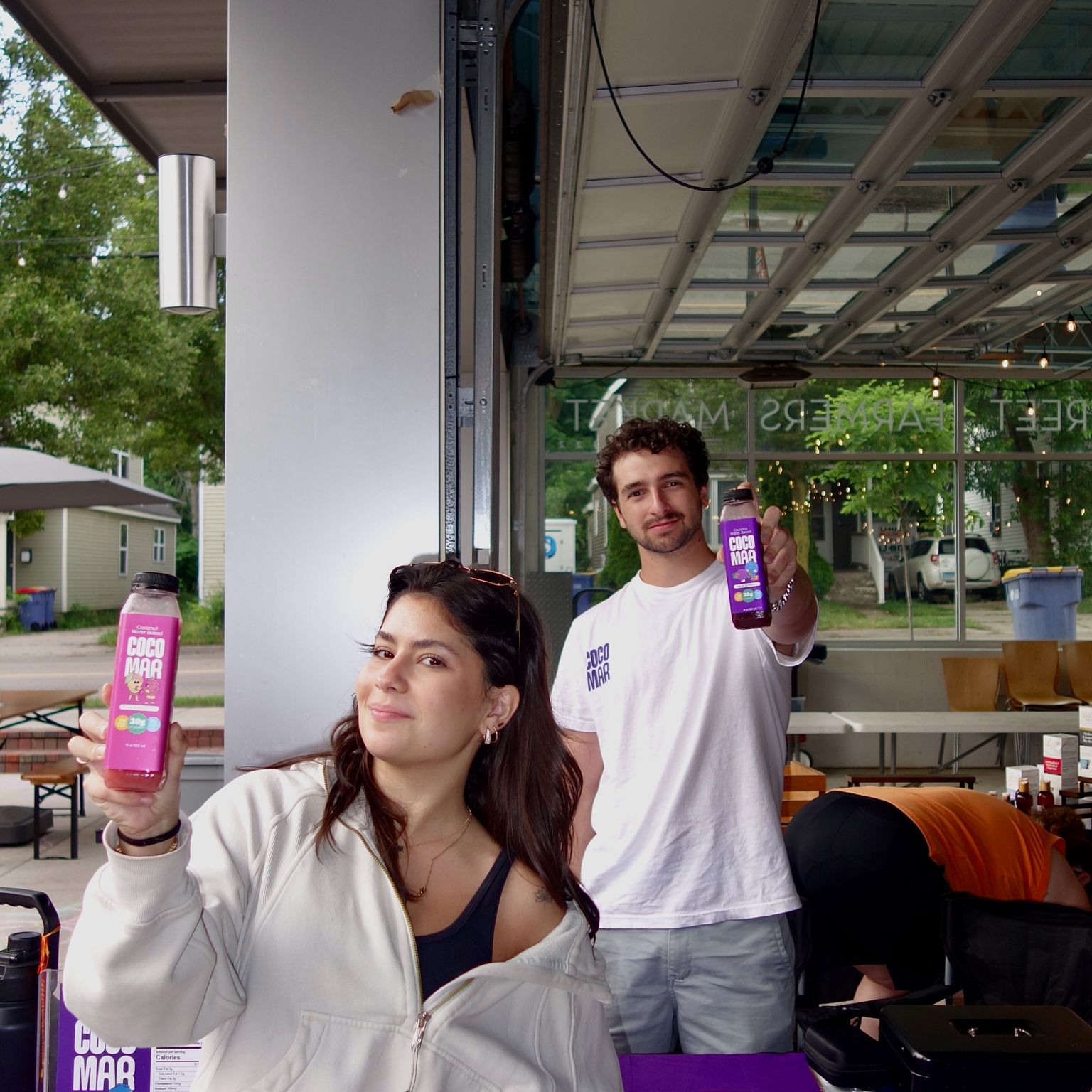 Two people holding Cocomar smoothies.