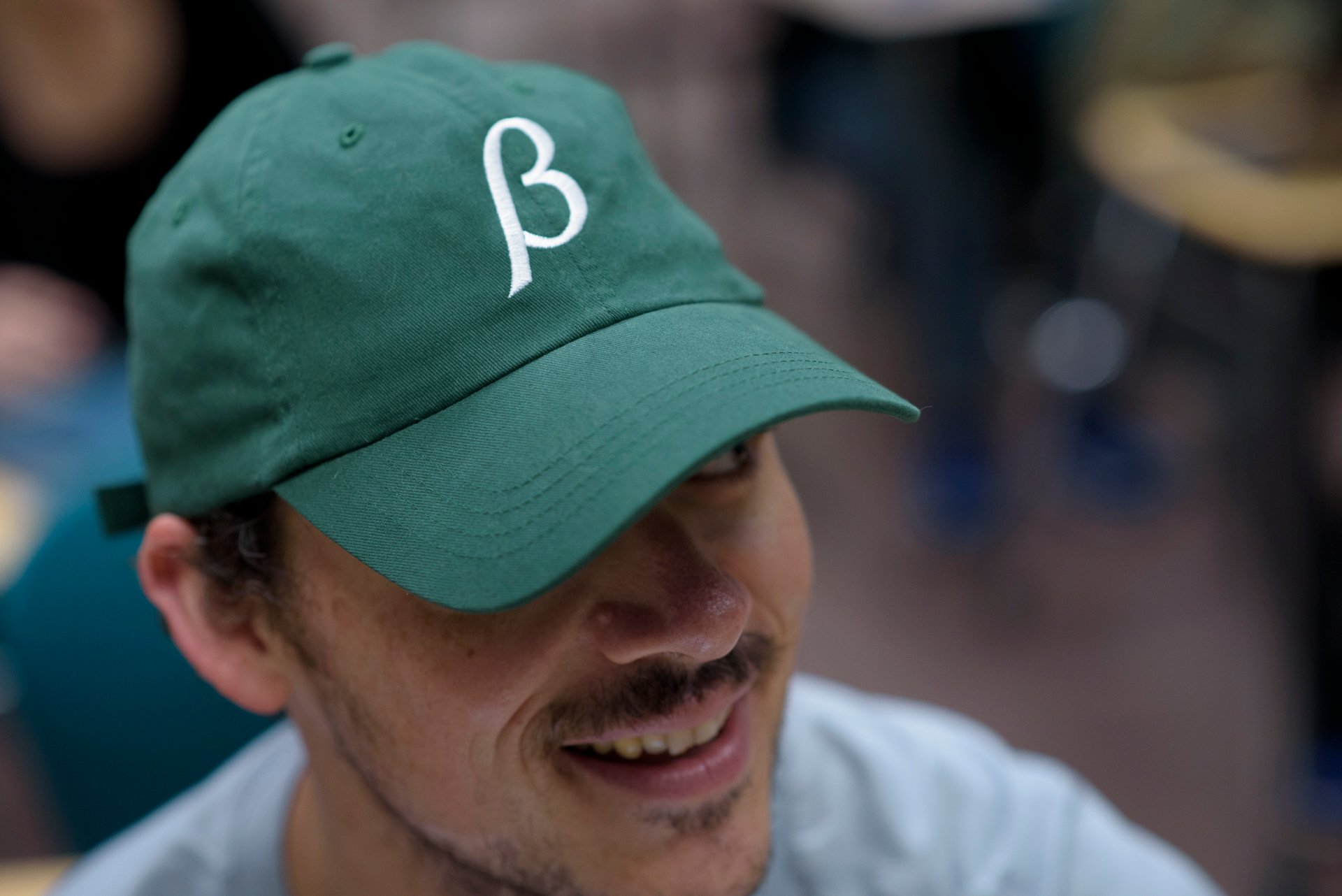 Person wearing green and white beta hat. 