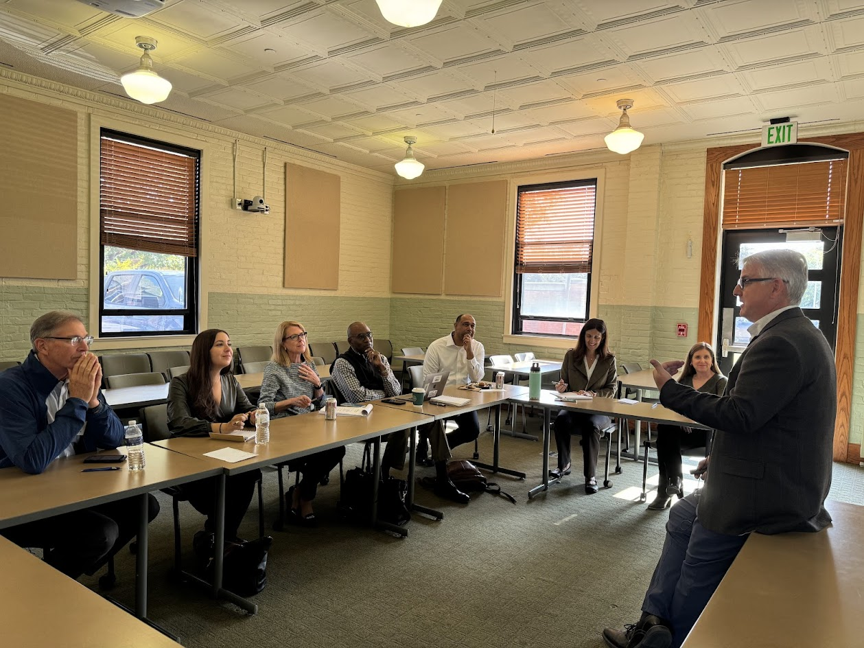 Men and women board members at their annual meeting and talk with department chair.