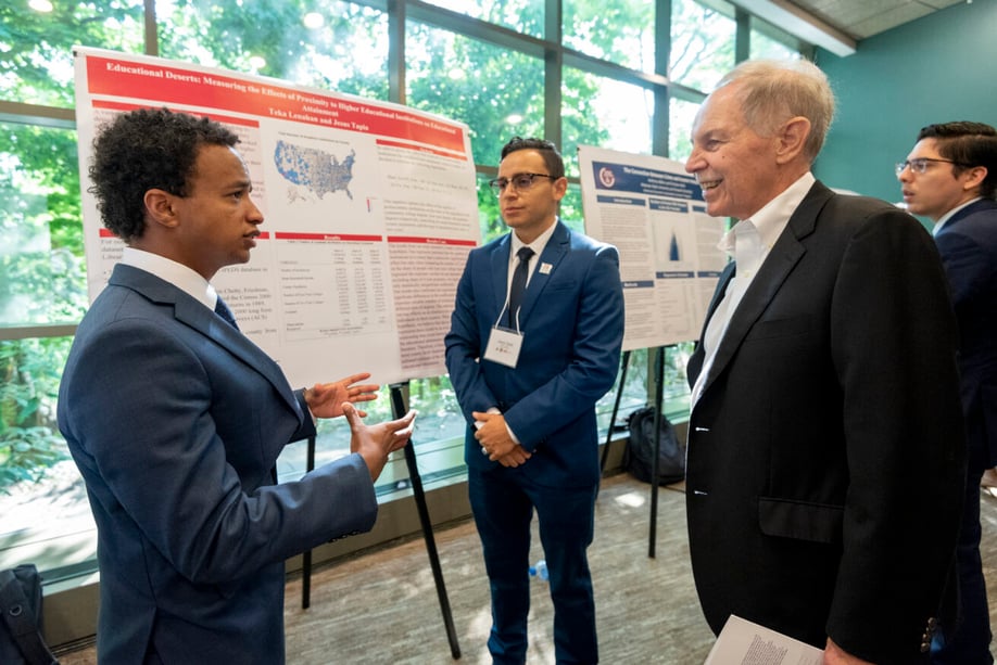 Fisher listens to a student poster presentation.