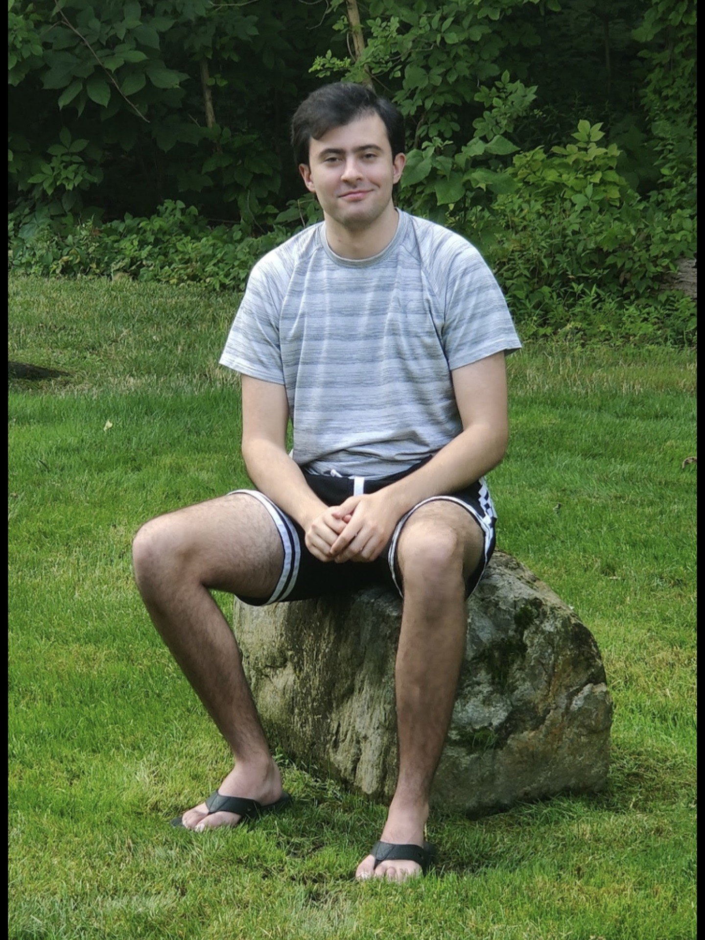 William Carvalho sits on a rock outside.