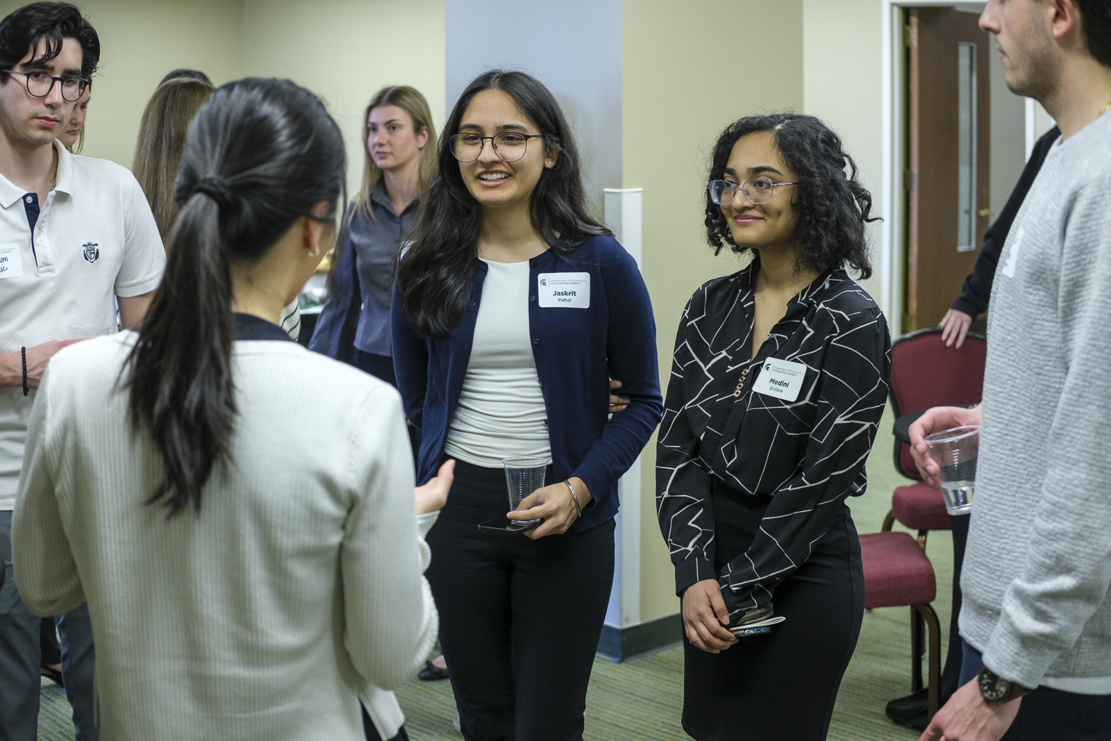 Alumna speaks with two students.