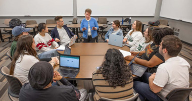 Professor Kristen Renn teaches in the middle of a circle of learners in Erickson Hall.