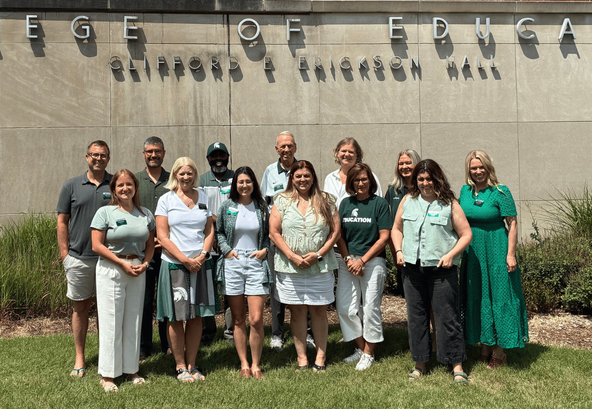 The CED Alumni Board standing as a group in front of Erickson Hall.
