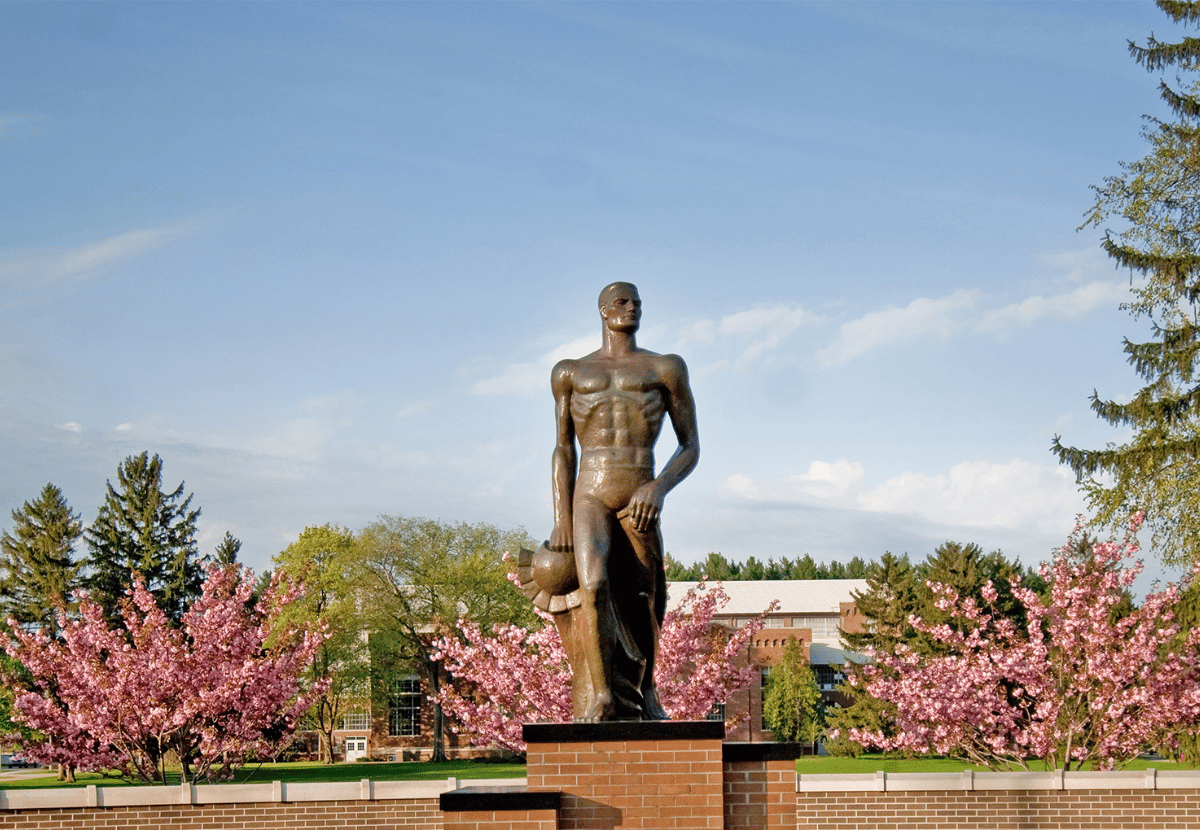 Sparty Statue surrounded by pink floral bushes
