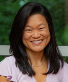 Courtenay Barrett headshot. Courtenay wears a lilack-colored blouse. Courtenay has black, shoulder-length hair.