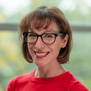 Pepa Casselman wearing a red shirt and glasses.