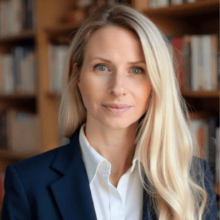 Lisa Dunlap wearing a dark suit jacket and a white shirt. She is standing in front of a bookshelf. 