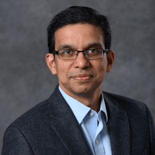 Rajiv Ranganathan wearing a dark suit jacket and glasses.