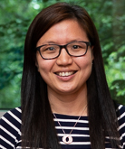 Connie Sung headshot. Connie smiles toward the camera while wearing dark-rimmed glasses and a shirt with black and white stripes. Connie's hair is long and black.