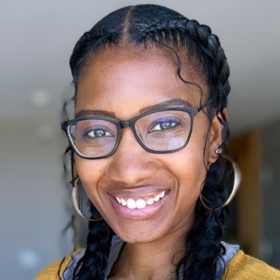 Headshot of Ciera Trice wearing a yellow sweater and glasses.