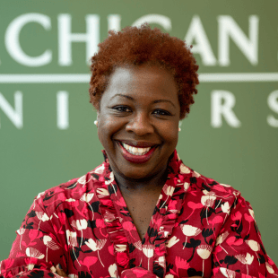 Sheneka Williams wearing a red floral shirt. 