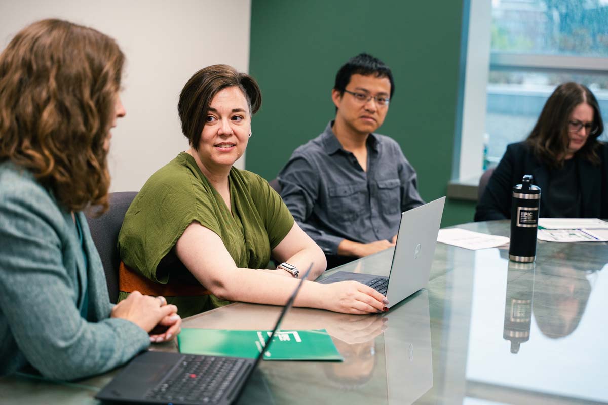 Scholars, staff and students in the Education Policy Innovation Collaborative discuss during a meeting.
