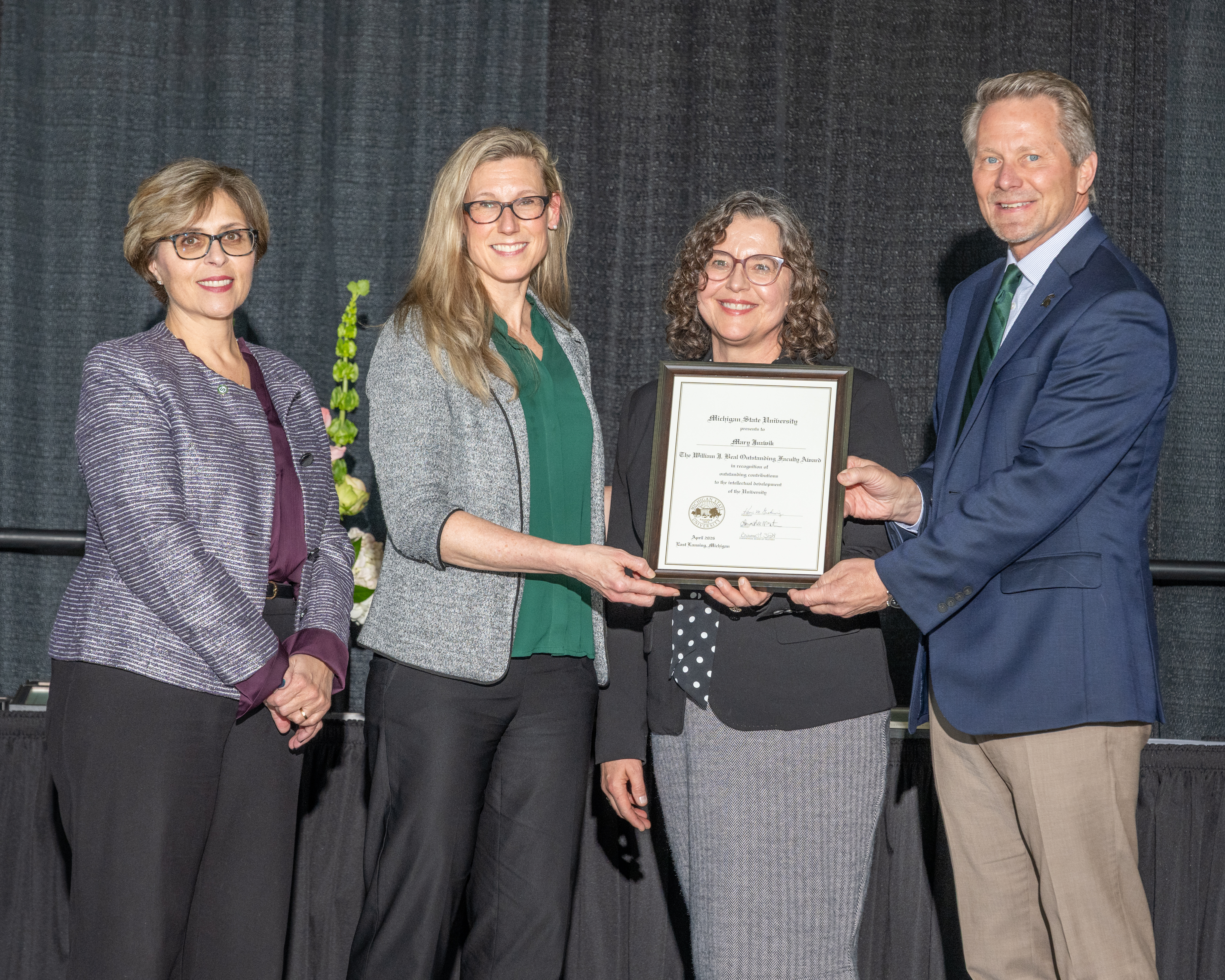 Several spartans pose for a photo during the MSU All-University Awards, including Provost Laura Lee McIntyre, Mary Juzwik and Kevin M. Guskiewicz.
