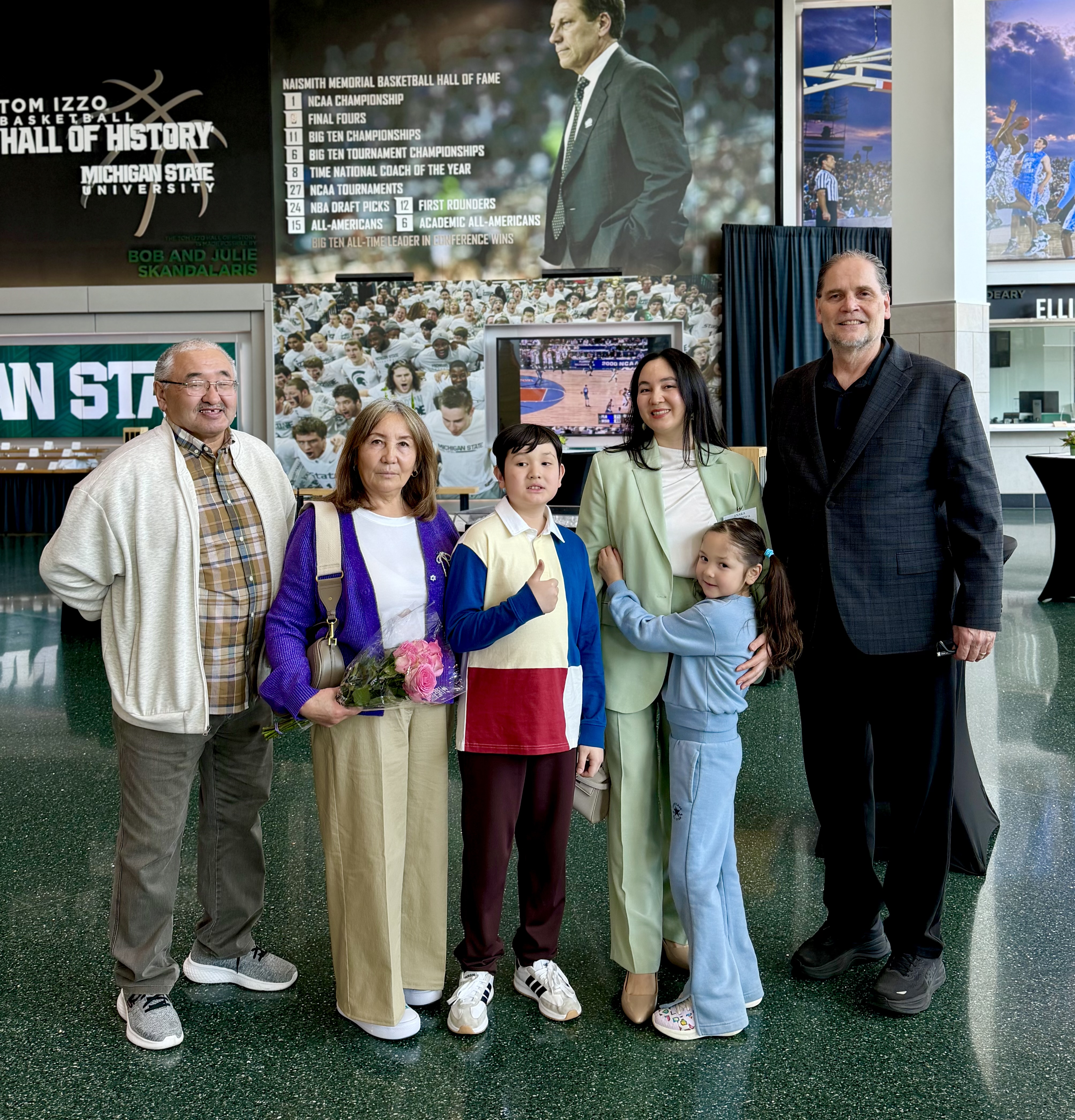 Anara Akhmetova poses with family and her academic advisor, Doug Hartman.