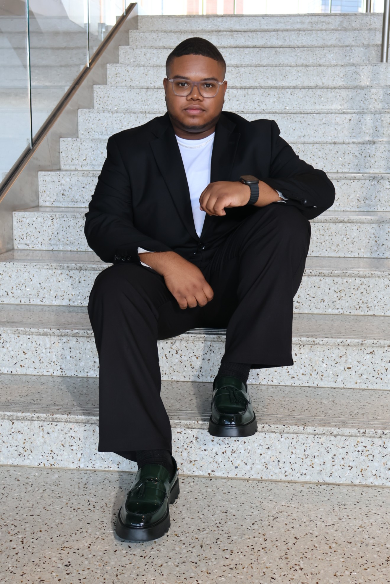 Jordan Simpson sits on steps and poses for the camera.