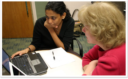 Two Spartans work together over a computer